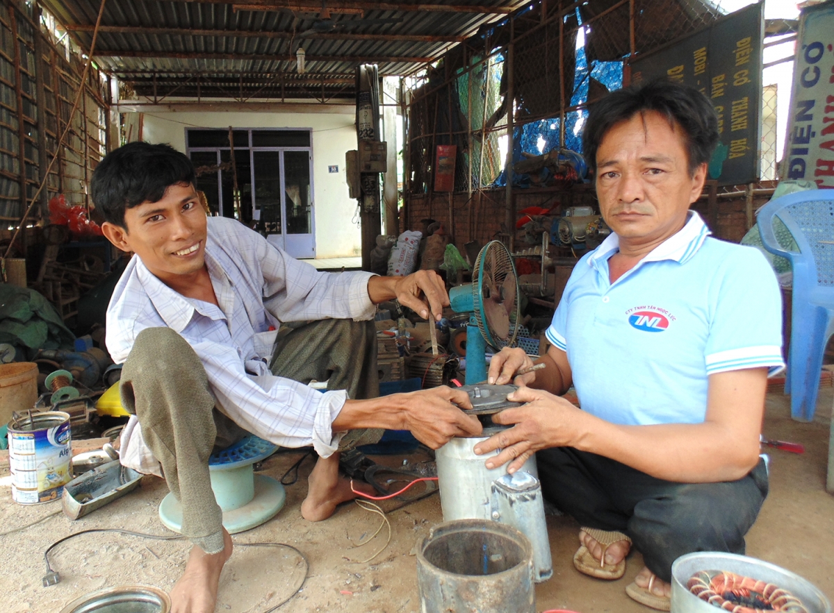 Anh Hóa (phía trái) đang hướng dẫn anh Trung quấn mô tơ