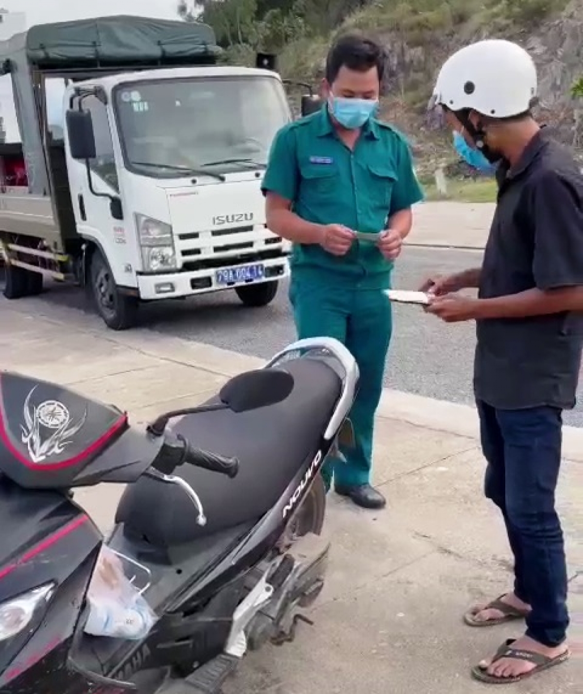 Người đi mua bánh mì (áo đen) bị tạm giữ xe và giấy tờ xe